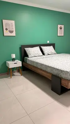 a bedroom with a bed and a blue wall at Duarte Apartments - Império in Mindelo
