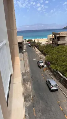a view of a street with cars parked on the beach at Duarte Apartments - Império in Mindelo