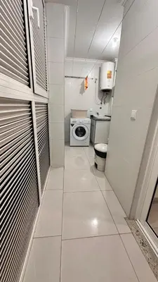 a small bathroom with a toilet and a washing machine at Duarte Apartments - Império in Mindelo