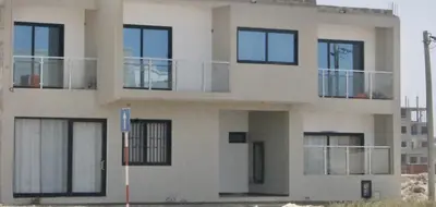 a white building with black windows and a street sign at KANDAKE APARTMENT II Sal Rei Wi-fi in Sal Rei