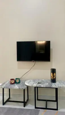 two tables in a room with a tv on a wall at KANDAKE APARTMENT II Sal Rei Wi-fi in Sal Rei