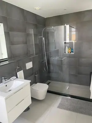 a bathroom with a shower and a toilet and a sink at Mendes Guesthouse in Tarrafal