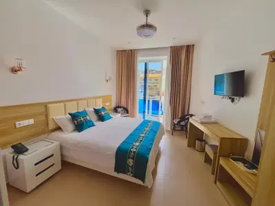 a hotel room with a bed and a television at Lily holiday hotel in Mindelo