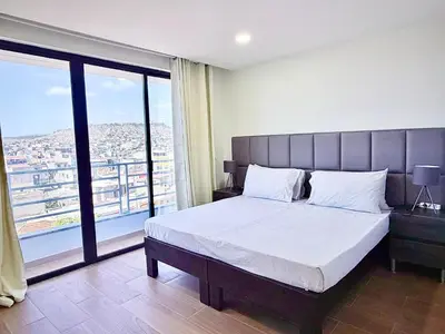 a bedroom with a large bed with a large window at My Home CV in Praia