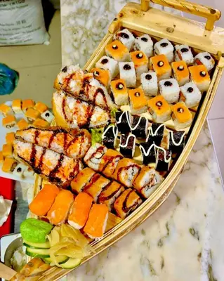 a tray of sushi and rolls on a table at My Home CV in Praia