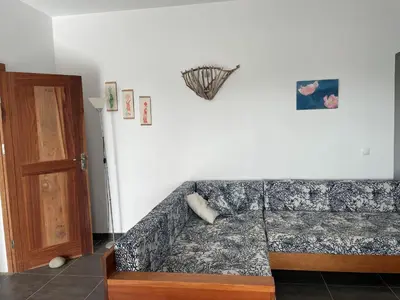 a living room with a couch and a wooden door at Magnifique villa avec piscine privée à 300m de la plage in Vila do Maio