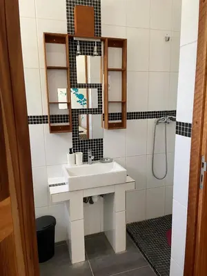 a bathroom with a sink and a shower at Magnifique villa avec piscine privée à 300m de la plage in Vila do Maio