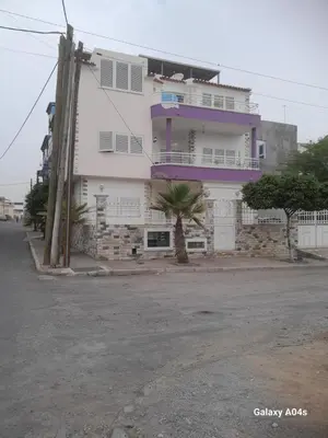 a white building with a palm tree in front of it at Apartamento espaçoso de 2 quartos amplos e mobilados in Praia