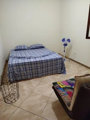 a bedroom with a bed and a fan on the wall at Apartamento espaçoso de 2 quartos amplos e mobilados in Praia