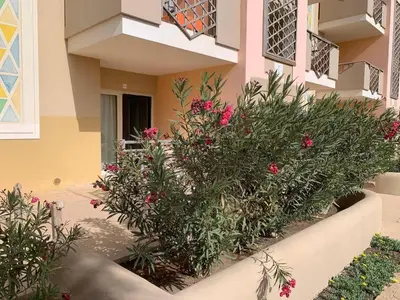 a bush with pink flowers in front of a building at Tropical Pool View - By Bobbywashere in Santa Maria
