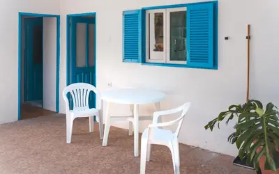 a white table and two chairs and a window at Oiá Paúl in Paul