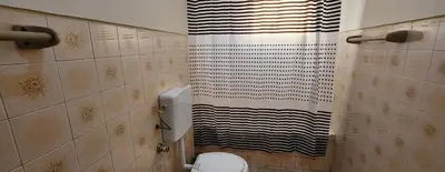 a bathroom with a toilet and a shower curtain at MEETING POINT HOSTEL-Praia Group Reservations in Praia
