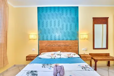 a bedroom with a bed with a blue wall at Tropical African Vibe in Santa Maria