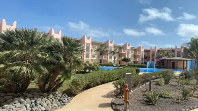 a resort with a swimming pool and palm trees at Tropical African Vibe in Santa Maria