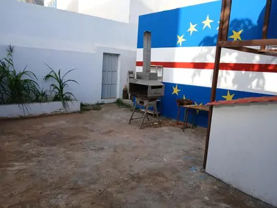 an empty room with an american flag painted on a wall at Mille Nuits Appartement in Tarrafal