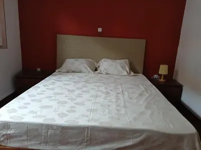 a bed with a white comforter and two pillows at Mille Nuits Appartement in Tarrafal