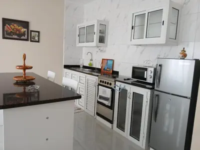 a kitchen with white appliances and black counter tops at Cozy Maia in Mindelo