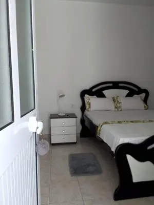 a bedroom with a bed and a dresser with a lamp at Cafofo in Tarrafal