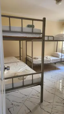 a room with three bunk beds in a room at Please Read Email-Free EARLY Check In & Out-No Walk-Ins or Cash Accepted-Meeting Point Hostels in São Filipe