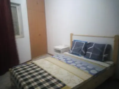 a small bedroom with a bed with blue pillows at Bar Residencial Frontera in Mindelo
