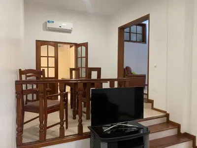 a living room with a table and chairs and a television at Two Bedroom Condo, Mindelo in Mindelo