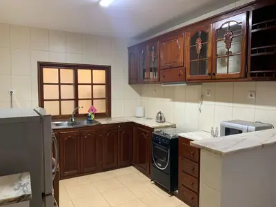 a kitchen with wooden cabinets and a black dishwasher at Two Bedroom Condo, Mindelo in Mindelo