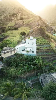 a white house on a hill with palm trees at Bentub Home pousada in Ribeira Grande