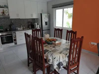a kitchen with a table with a bowl of fruit on it at Bentub Home pousada in Ribeira Grande