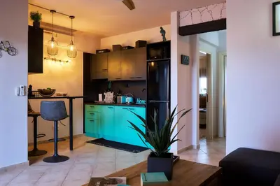 a kitchen with blue cabinets and a black refrigerator at Tropical Manera in Santa Maria