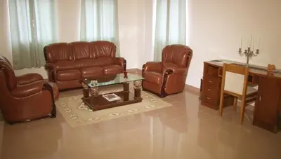 a living room with leather chairs and a table at Residencial Cosmos in Assomada