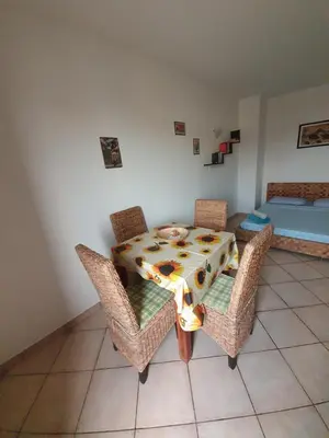 a dining room with a table and chairs and a bed at Holiday Properties Commercial Center - Wi-fi in Santa Maria