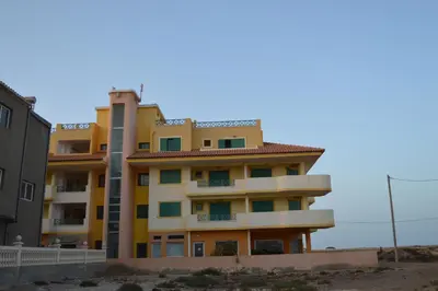 a yellow apartment building on the beach at Holiday Properties Commercial Center - Wi-fi in Santa Maria