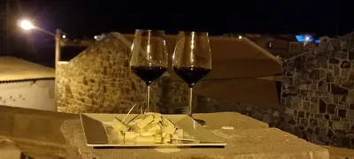 two glasses of wine and a plate of cheese at Liminha Guest House in Calheta de São Miguel