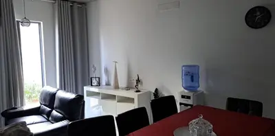 a living room with a couch and a table and a tv at Liminha Guest House in Calheta de São Miguel