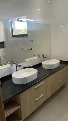 a bathroom with two sinks and a large mirror at Condomínio Horizonte in Praia