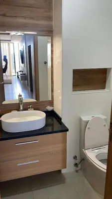 a bathroom with a sink and a toilet and a mirror at Condomínio Horizonte in Praia