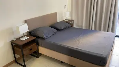 a bedroom with a bed with two night stands and two lamps at Condomínio Horizonte in Praia