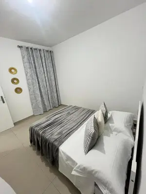 a bedroom with a bed with white sheets and pillows at Casabeleza Cape Verde in Assomada