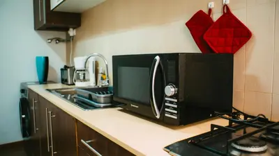 a microwave sitting on a kitchen counter next to a stove at Prainha Beach Apartment I in Praia