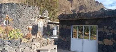 a stone building with a door and a bench at Casa Mamã in Portela