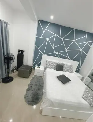 a bedroom with a white bed and a blue wall at Peace of mind in Praia