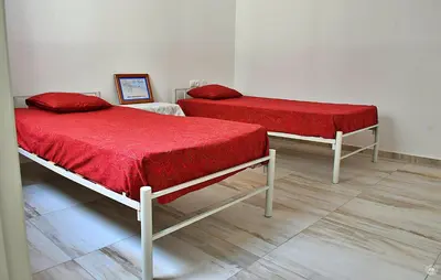 two beds with red covers in a room at Casa Magui e Cláudio in Tarrafal