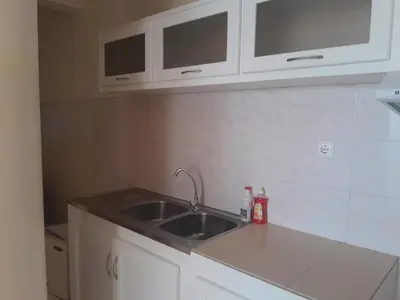 a kitchen with a sink and white cabinets at Casa Magui e Cláudio in Tarrafal