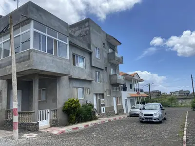 a building with two cars parked in front of it at Casa Magui e Cláudio in Tarrafal