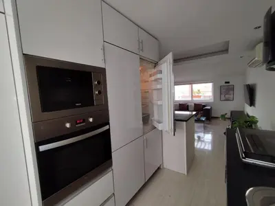 a kitchen with a stove and a microwave at Apartamento T1, amplo e arrejado in Praia