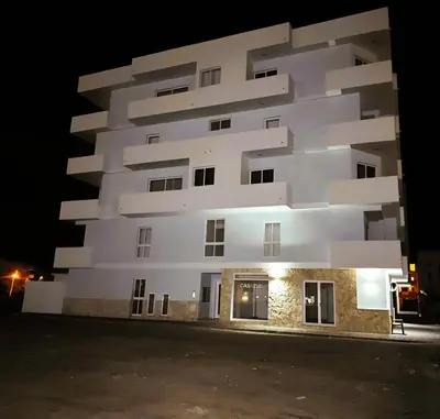 a tall white building at night at Apartment Boadventure in Sal Rei