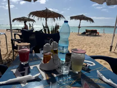 a table on the beach with drinks and umbrellas at Apartment Boadventure in Sal Rei