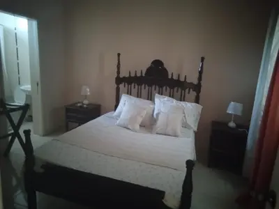 a bedroom with a bed with white sheets and pillows at Morabeza Praia in Praia