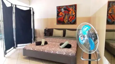 a bedroom with a bed and a fan at Studio Murdeira Side Beach, Eco Protected Bay, Pool in Beirona
