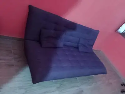 a black couch in a room with a pink wall at ApartamentoT1 Ponta do Sol in Ponta do Sol